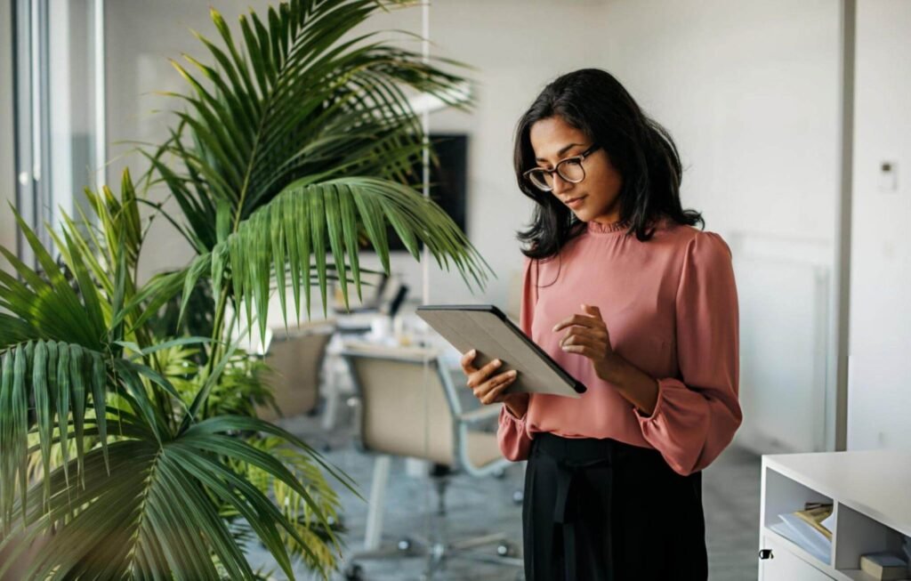 Office professional using a tablet while reviewing work in a modern workspace